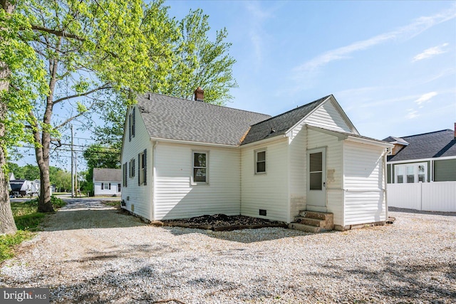 2708 Old Ocean City Rd, Salisbury, MD 21804 - rear view of property featuring entry steps, a chimney, gravel driveway, and a shingled roof