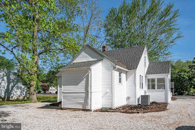 2708 Old Ocean City Rd, Salisbury, MD 21804 - view of home's exterior with a shingled roof, a chimney, and cooling unit