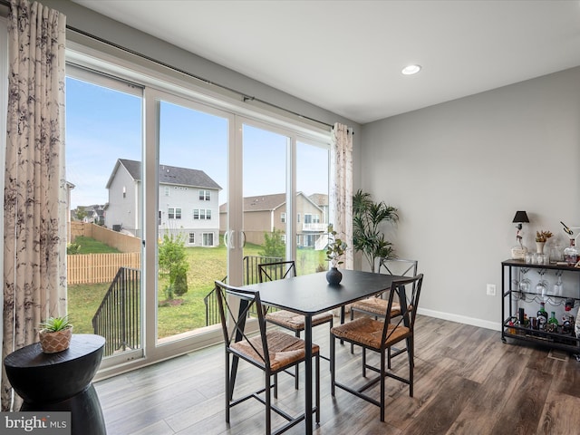 dining space featuring recessed lighting, plenty of natural light, and wood finished floors