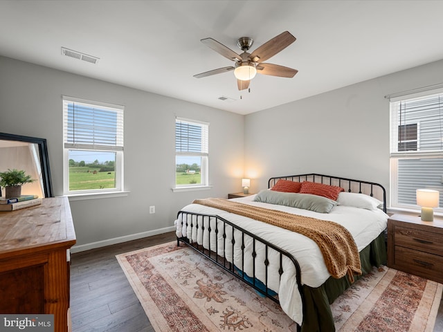 bedroom with ceiling fan, baseboards, visible vents, and wood finished floors