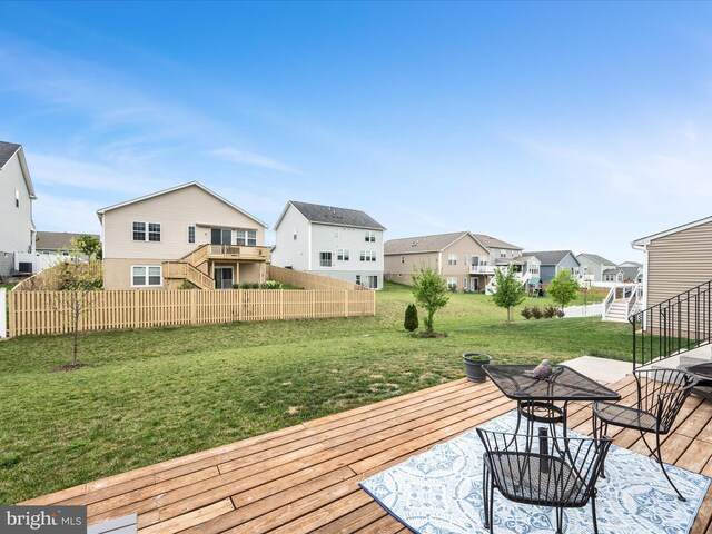 deck with a residential view, fence, and a yard