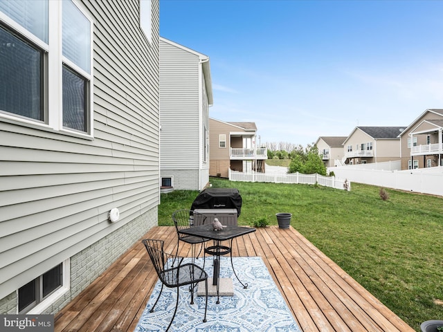 wooden deck with area for grilling, a lawn, fence, and a residential view