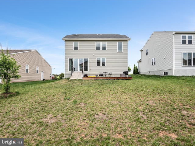 back of property with a yard and a wooden deck