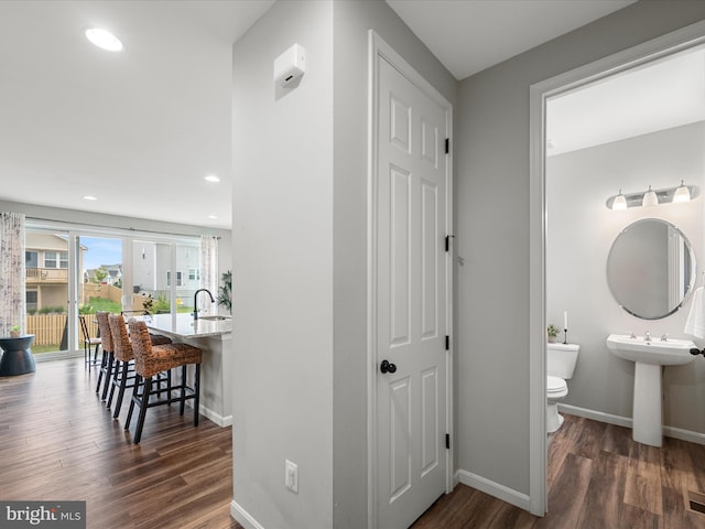 corridor featuring recessed lighting, baseboards, and dark wood-style floors