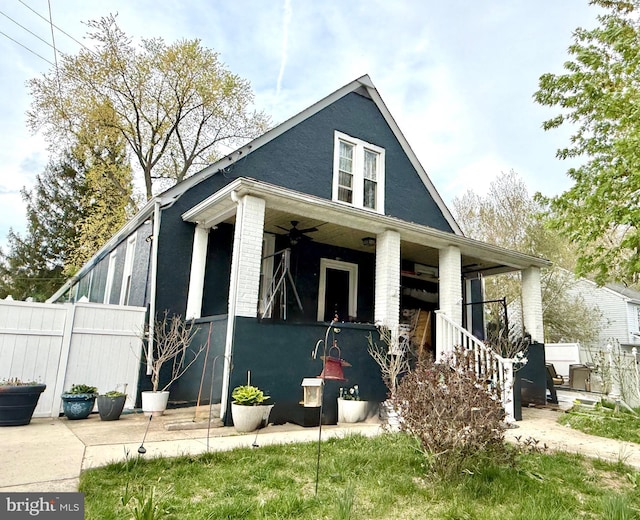 view of front of property featuring fence, a ceiling fan, stairs, and a porch