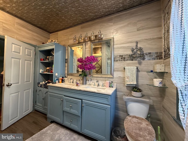 full bath featuring a sink, an ornate ceiling, double vanity, and wood finished floors
