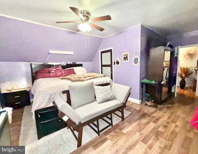 bedroom with baseboards, lofted ceiling, wood finished floors, and ceiling fan