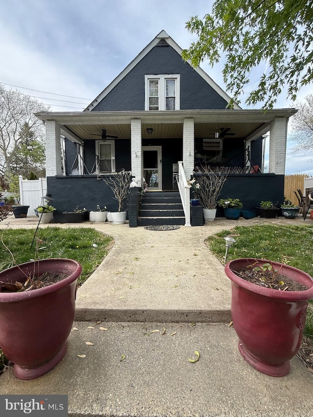 bungalow-style house with a porch, fence, and brick siding