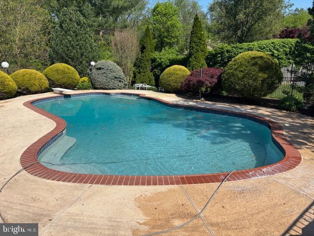 pool featuring fence and a patio
