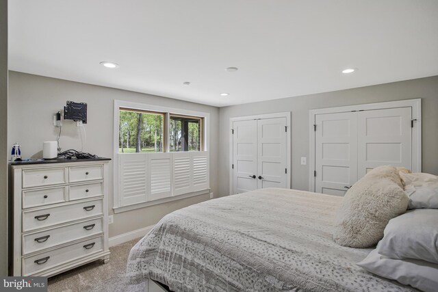 bedroom with carpet, baseboards, multiple closets, and recessed lighting