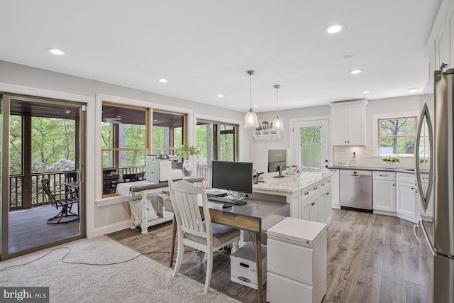 office with recessed lighting and light wood-style floors
