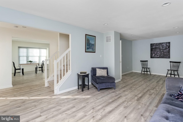 living room featuring visible vents, stairs, baseboards, light wood-style floors, and recessed lighting