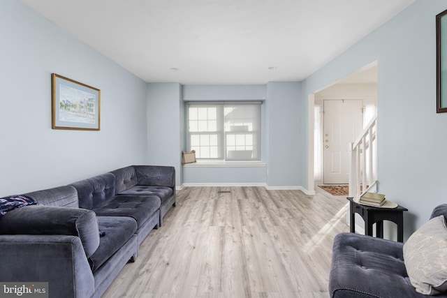 living room with baseboards and light wood-style flooring
