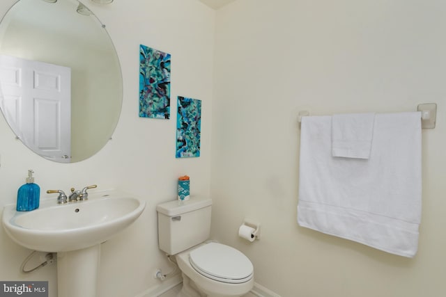 bathroom with toilet and baseboards