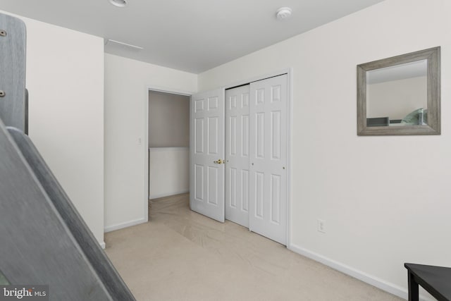 unfurnished bedroom with baseboards, carpet flooring, and a closet