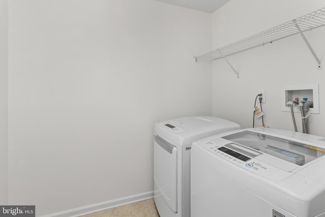 laundry room with baseboards, laundry area, and washing machine and dryer