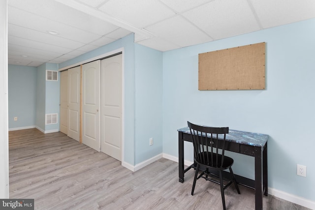 home office featuring visible vents, a paneled ceiling, and wood finished floors