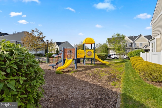 community jungle gym with a residential view and fence