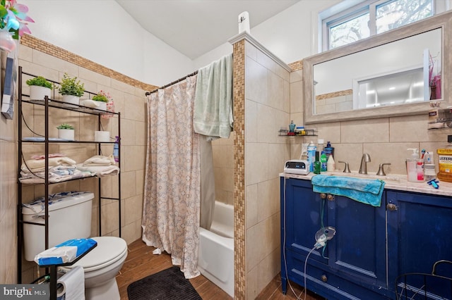 bathroom featuring tile walls, wood finished floors, vanity, toilet, and shower / bath combo with shower curtain