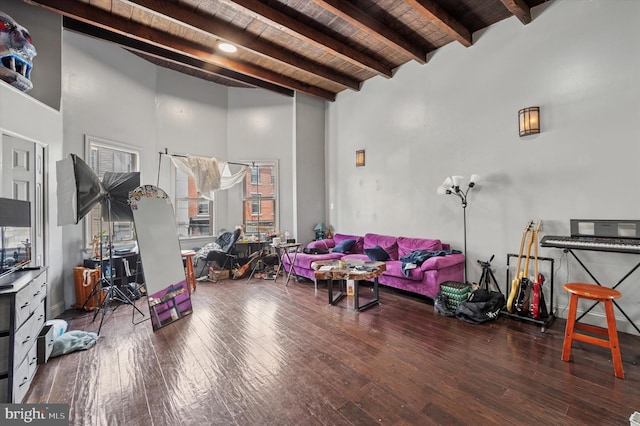 living room with wooden ceiling, wood finished floors, beam ceiling, and a towering ceiling