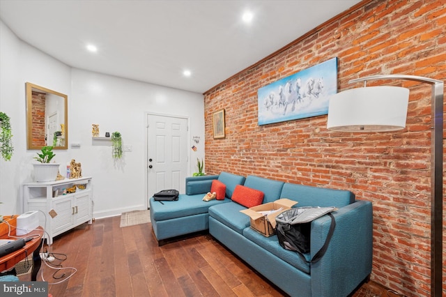 living area featuring hardwood / wood-style floors, baseboards, recessed lighting, and brick wall