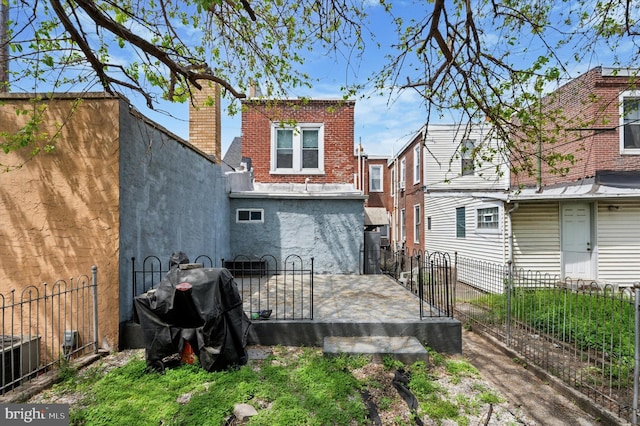rear view of property with fence private yard, a patio area, and brick siding