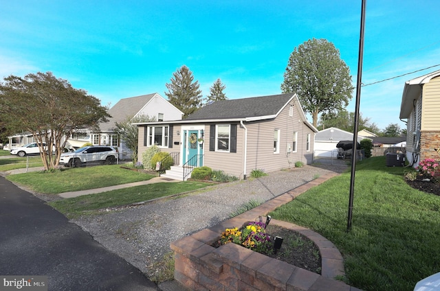 221 Arundel Rd, Pasadena, MD 21122 - bungalow-style home with a shingled roof, fence, a front yard, and a detached garage