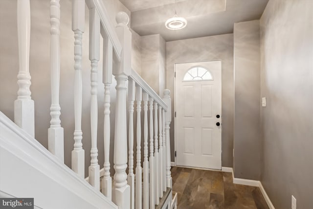foyer featuring baseboards and dark wood finished floors