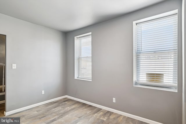 empty room featuring baseboards and wood finished floors