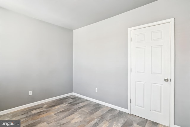 empty room featuring baseboards and wood finished floors