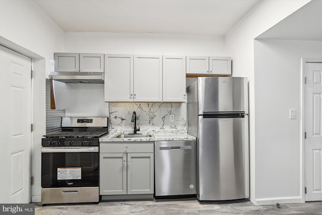 kitchen featuring a sink, appliances with stainless steel finishes, gray cabinets, and under cabinet range hood