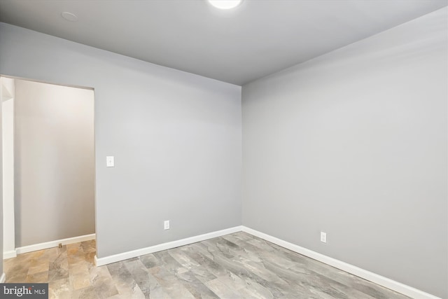 unfurnished room with baseboards
