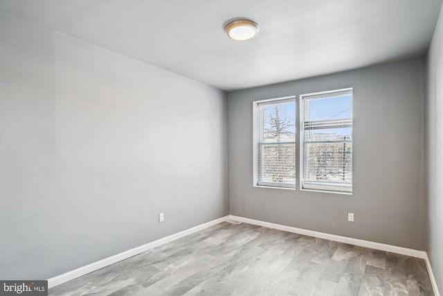 unfurnished room featuring baseboards and wood finished floors