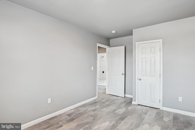 unfurnished bedroom featuring baseboards and wood finished floors