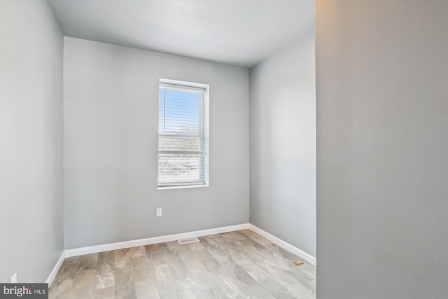 empty room featuring baseboards and visible vents