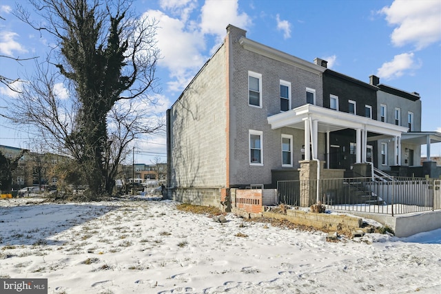 view of property featuring brick siding and fence