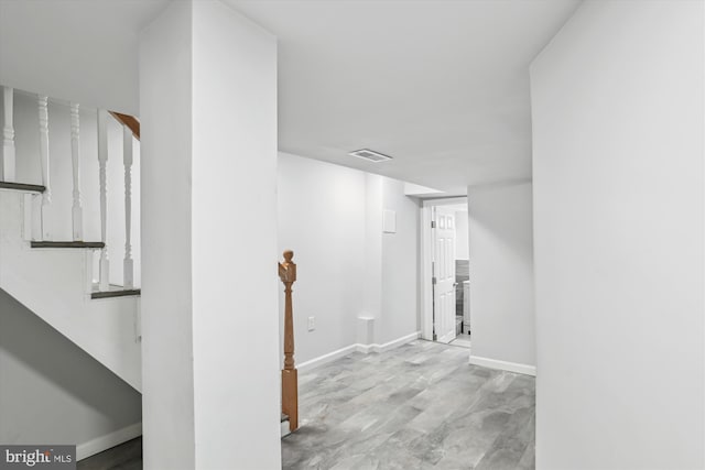 interior space featuring baseboards, visible vents, and stairway