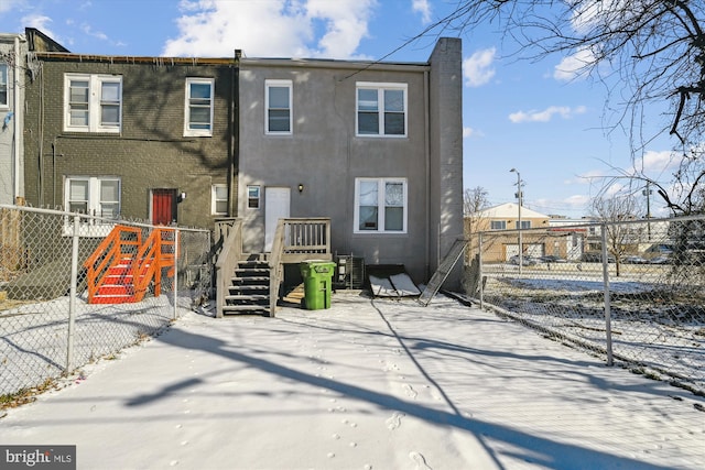 snow covered property featuring fence and a wooden deck