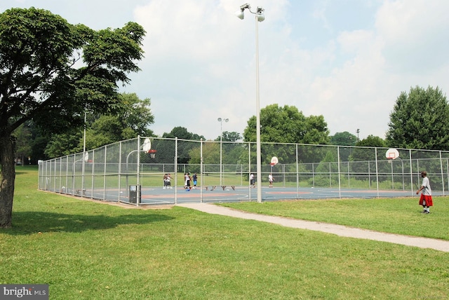 view of basketball court featuring fence, community basketball court, and a yard