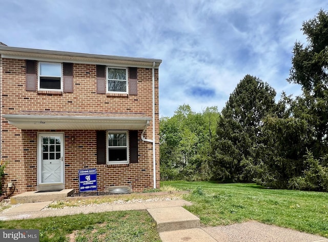 view of front of property featuring brick siding and a front yard