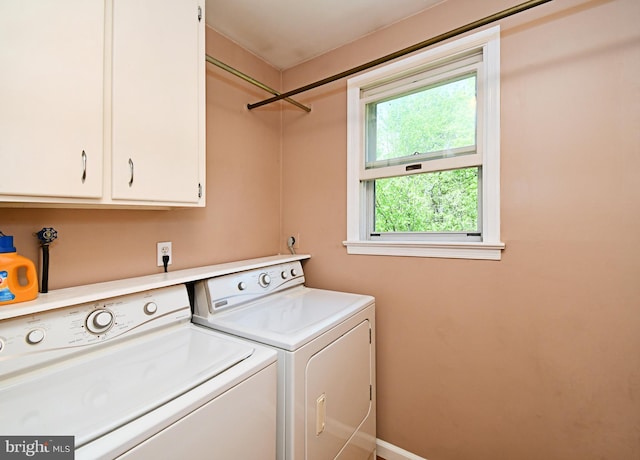 laundry area featuring separate washer and dryer, baseboards, and cabinet space