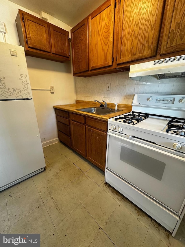 4710 12th St NE, Washington, DC 20006 - kitchen with white appliances, under cabinet range hood, tasteful backsplash, brown cabinetry, and a sink