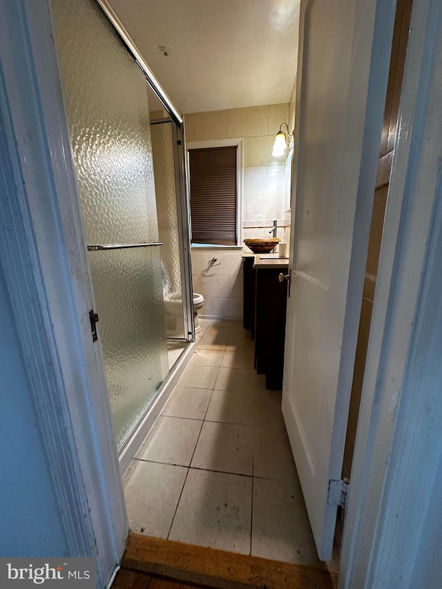 4710 12th St NE, Washington, DC 20006 - bathroom with vanity, a shower stall, toilet, tile patterned flooring, and tile walls