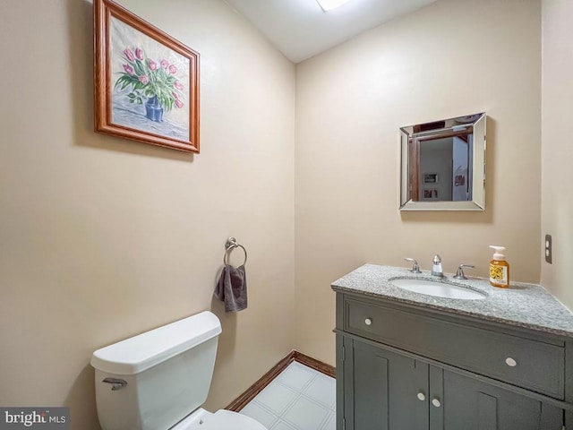bathroom with toilet, baseboards, tile patterned floors, and vanity