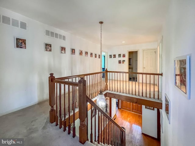 corridor featuring visible vents and an upstairs landing