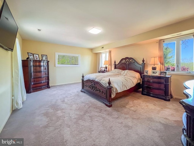 carpeted bedroom featuring baseboards and visible vents