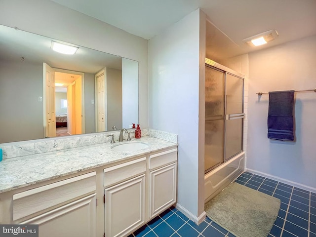 ensuite bathroom with vanity, baseboards, connected bathroom, tile patterned floors, and enclosed tub / shower combo