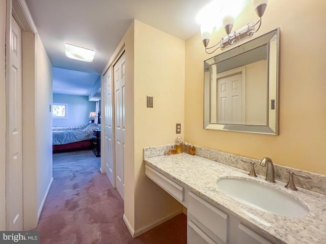 bathroom with vanity, baseboards, and ensuite bathroom