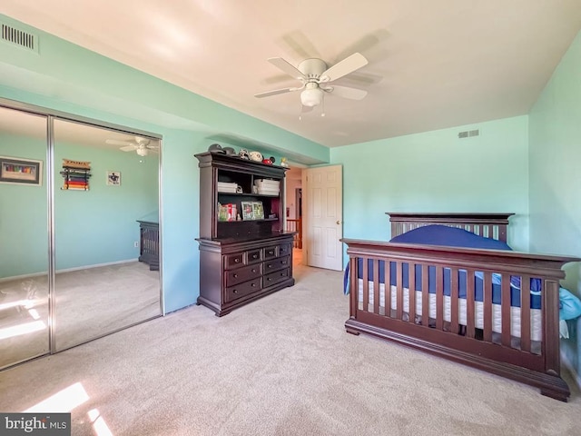 bedroom featuring carpet floors, a ceiling fan, visible vents, and a closet