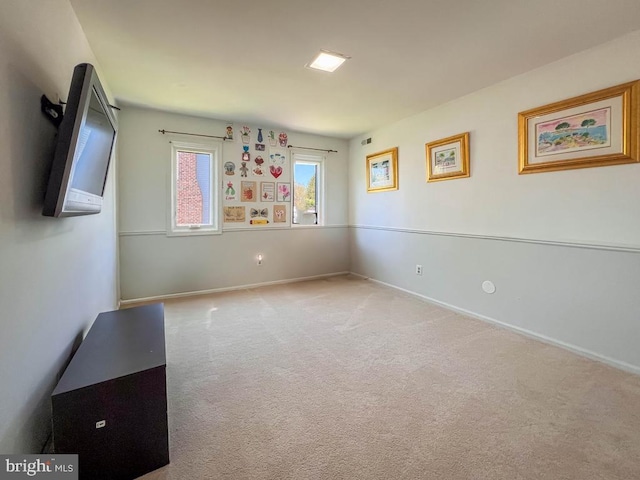 carpeted empty room featuring baseboards